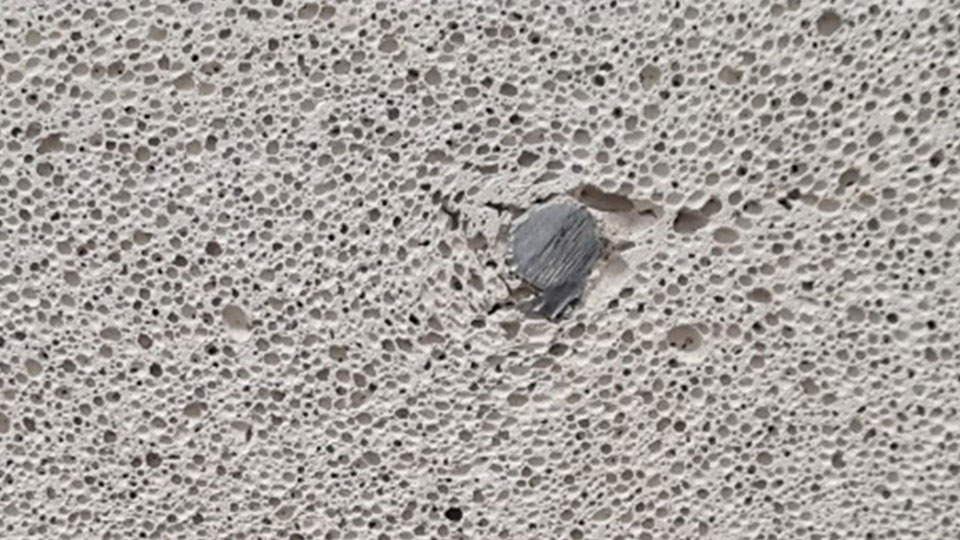 A close-up of Reinforced Autoclaved Aerated Concrete showing the porous surface
